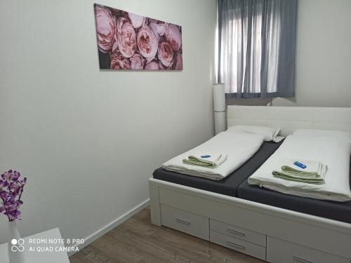 a bedroom with a bed with two towels on it at Adessa Apartment in Bad Mergentheim