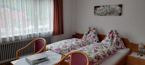 a room with a bed and a table with chairs at Pension Wildental in Sankt Martin bei Lofer