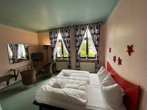 1 dormitorio con cama, escritorio y ventana en Hotel-Sternthaler /Rathauseck, en Müncheberg