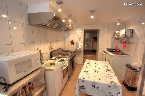 une cuisine avec une cuisinière et un micro-ondes dans l'établissement BONSEJOUR, à Saint-Maurice-sur-Moselle