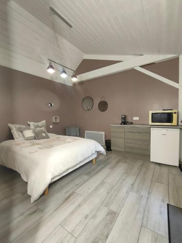 une chambre avec un lit et une télévision au mur dans l'établissement Jolies Chambres familiales à 10 minutes du Puy du Fou, aux Herbiers