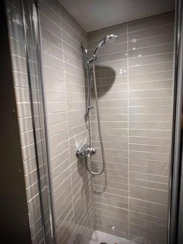 a shower in a bathroom with a glass door at Historic & Stylish Cottage in Charlton Kings