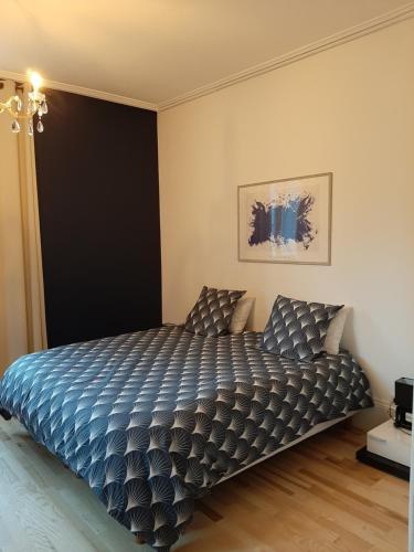 a bedroom with a bed with a blue comforter at La chambre de maître du boulevard Thiers, entrée et terrasse privatives in Remiremont