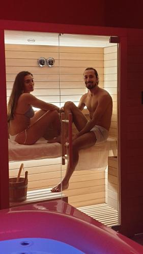 um homem e uma mulher sentados numa sauna em Accanto Alle Mura Rooms & Relax Spa em Sirolo