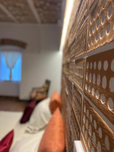 a brick wall next to a bed in a room at Arcadia Agriturismo in San Nicola Manfredi