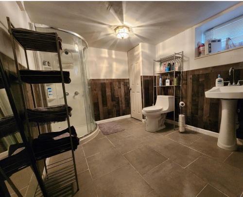 a bathroom with a shower and a toilet and a sink at Cozy Studio; Lower Level Unit in Laurelton