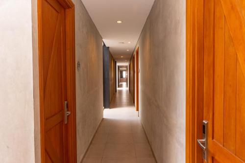 a long hallway with wooden doors and a hallwayngth at Hotel Summerville in Majalengka