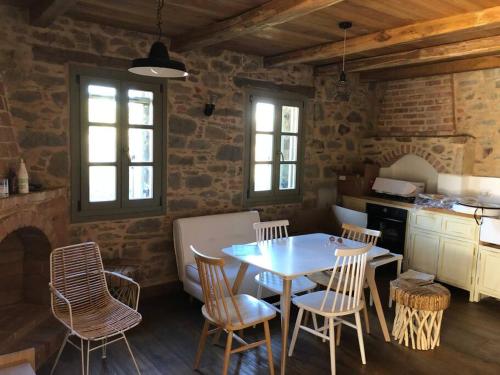 kuchnia ze stołem i krzesłami w pokoju w obiekcie Lemon's Cottage House, Volissos, Chios w mieście Volissos
