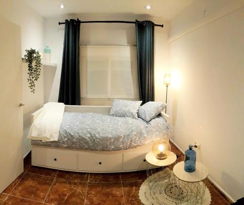 a bedroom with a bed with a window and two tables at Casa del Castillo by Naturadrada in La Adrada