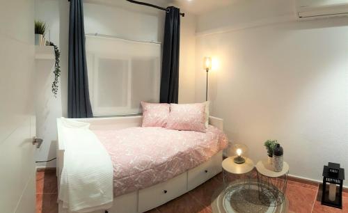 a bedroom with a bed with pink pillows and a window at Casa del Castillo by Naturadrada in La Adrada