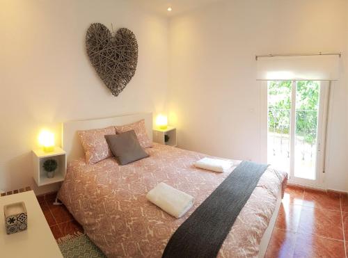 a bedroom with a bed and a heart on the wall at Casa del Castillo by Naturadrada in La Adrada