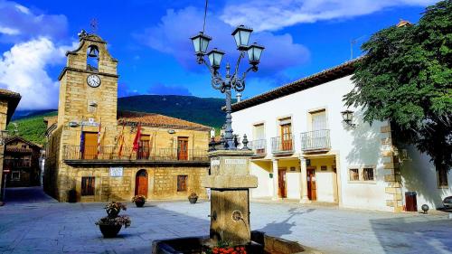 a building with a clock tower and a building with a street light at Casa del Castillo by Naturadrada in La Adrada