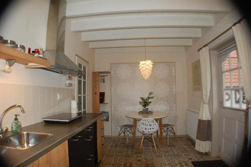 a kitchen with a table and a dining room at B&B BeZINspiratie in Schuinesloot