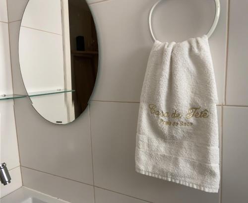 a towel hanging in front of a mirror in a bathroom at Apartamento térreo confortável no Condomínio Villa das Águas in Estância