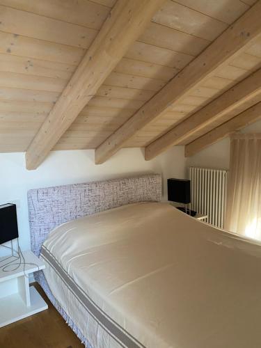 a large bed in a room with wooden ceilings at Cascina Jesolana in Lido di Jesolo