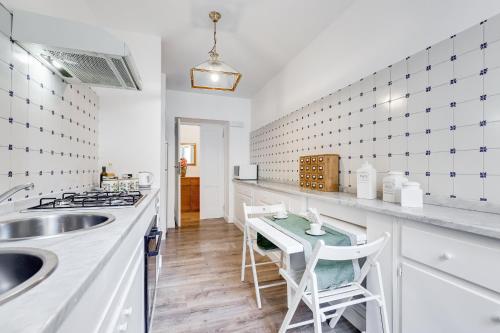 a kitchen with a sink and a counter with stools at Living Rome Repubblica apartment in Rome