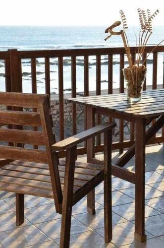 a wooden table and chair with a vase on a table at Oltremare Marzamemi in Marzamemi
