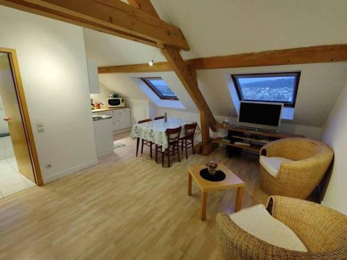 een woonkamer met een tafel en stoelen en een televisie bij Appartement - Stiring-Wendel in Stiring-Wendel