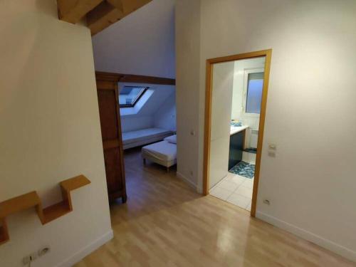 een kamer met een slaapkamer met een bed en een spiegel bij Appartement - Stiring-Wendel in Stiring-Wendel