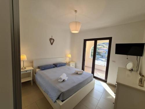 1 dormitorio con 1 cama con 2 toallas en Zambrone Beach Villas en Zambrone