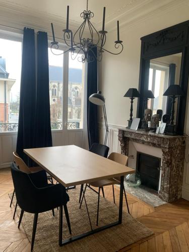 une salle à manger avec une table et des chaises et une cheminée dans l'établissement L Oôte appart, à Épernay