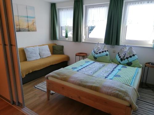 1 dormitorio con 1 cama y 1 sofá en Nikolaus und Evelyn Astner, Ferienwohnungen mit PlusCard Berg u See Erlebnis inkludiert, en Tröpolach