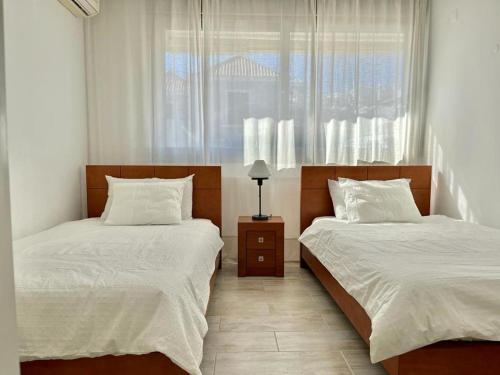 a bedroom with two beds and a window at Charming Tavira - Pools Pet-Friendly Golf in Tavira