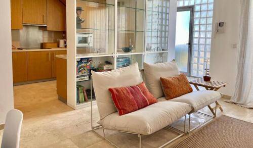 a living room with a white couch with colorful pillows at Charming Tavira - Pools Pet-Friendly Golf in Tavira