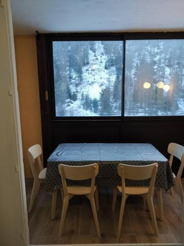 een kamer met een tafel en stoelen en een raam bij Studio Azur Mercantour in Valdeblore