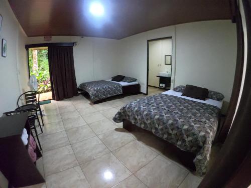 a hotel room with two beds and a window at Hotel Rio Celeste to Know in Rio Celeste