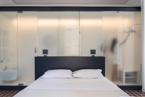 a bedroom with a large bed with white sheets at Casa Ruiz Suites in Noto