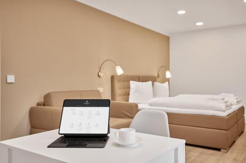 Boardinghotel Premium Heidelberg في هايدلبرغ: جهاز كمبيوتر محمول على طاولة في غرفة مع سرير