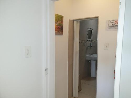a white bathroom with a sink and a toilet at The Haven: Make our Home your Home in Estcourt
