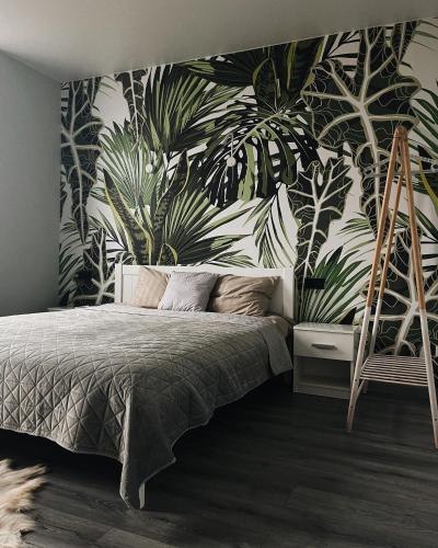 a bedroom with a bed with a tropical wallpaper at MoonLight in Slavske