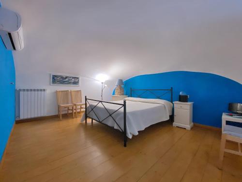 a bedroom with a bed and a blue wall at Terrazza sul Vesuvio con piscina in Terzigno