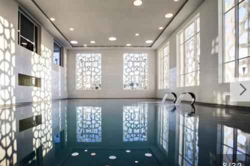 an empty swimming pool with two faucets in a room with windows at Appartement Bahia Golf Beach in Bouznika