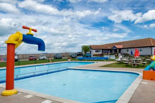 a swimming pool with a water slide in a resort at Seaview Park Premium Static Caravan Whitstable in Whitstable