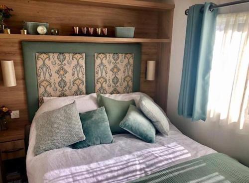 1 cama con almohadas en el dormitorio en Seaview Park Premium Static Caravan Whitstable, en Whitstable