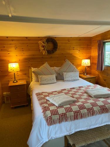 a bedroom with a large bed with two lamps at The Lodge On The Marsh in Brading