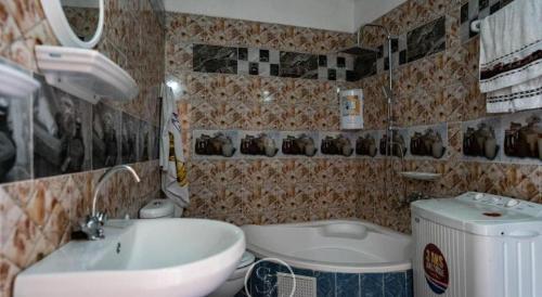 a bathroom with a sink and a toilet and a tub at Dar Fatma Toujane in Tūjān