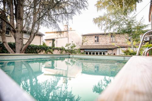 una piscina frente a un edificio en Chambres le Cèdre lezoux, en Lezoux