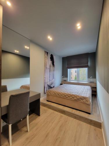 a bedroom with a large bed and a desk and a desk at Czernowitz Deluxe Apartments in Chernivtsi