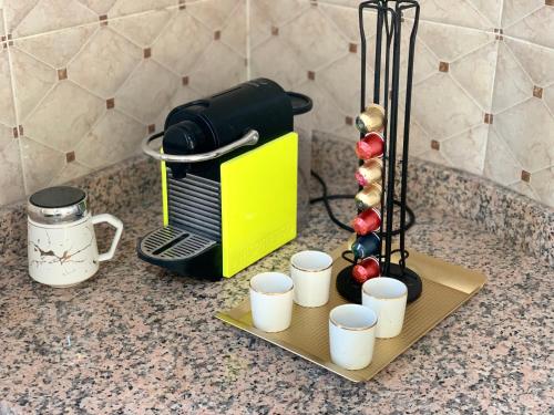 a counter with a coffee maker and cups on a tray at Most Beautiful Apartment in Safi in Safi