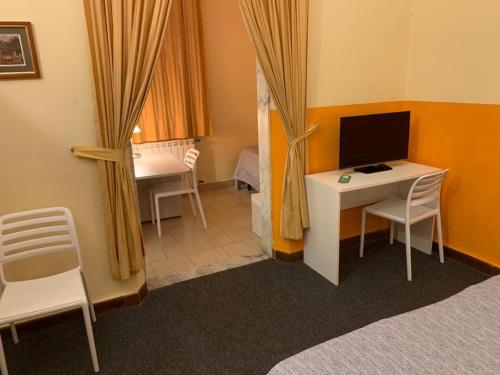 a room with a desk with a monitor and a computer at Hotel Annunziata in Massa