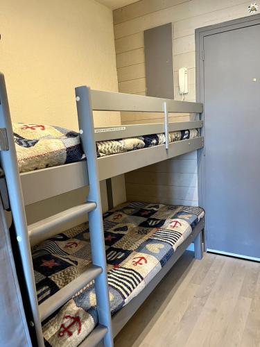 Ce dortoir comprend 2 lits superposés et une porte. dans l'établissement Studio 4 personnes à Saint-Mandrier-sur-Mer, à Saint-Mandrier-sur-Mer