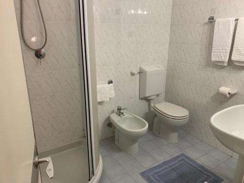 a bathroom with a shower and a toilet and a sink at Hotel Annunziata in Massa