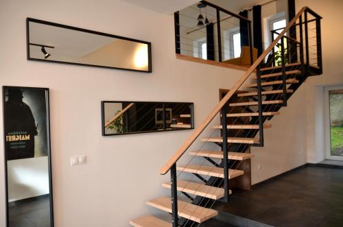a spiral staircase in a house with a mirror at Loft industriel dans une ancienne grange in Guenviller