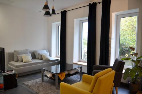 a living room with a couch and a table at Loft industriel dans une ancienne grange in Guenviller
