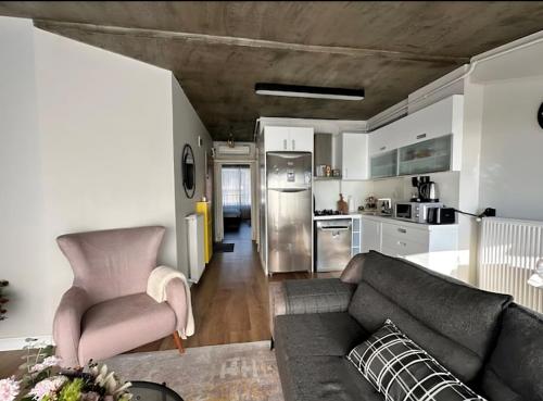 sala de estar con sofá y cocina en Bosphorus Seaview flat & Alexa smart home by SUMMITVISTA, en Estambul