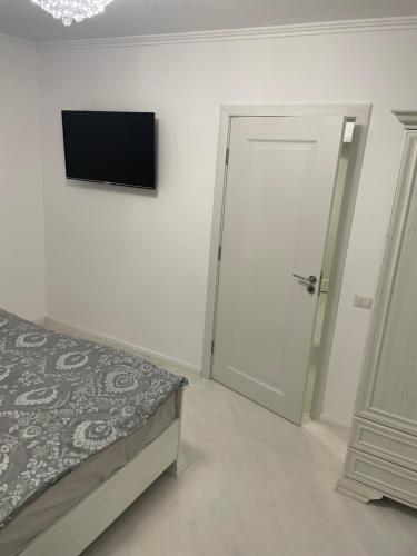 um quarto com uma cama e uma televisão na parede em Marasesti Studio em Suceava